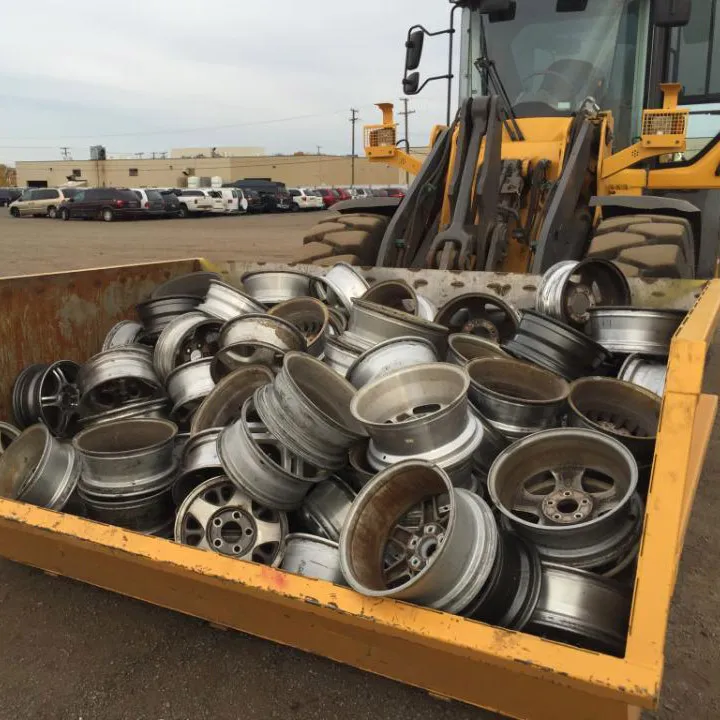 Loader handling sorted aluminum wheel scrap at a materials yard